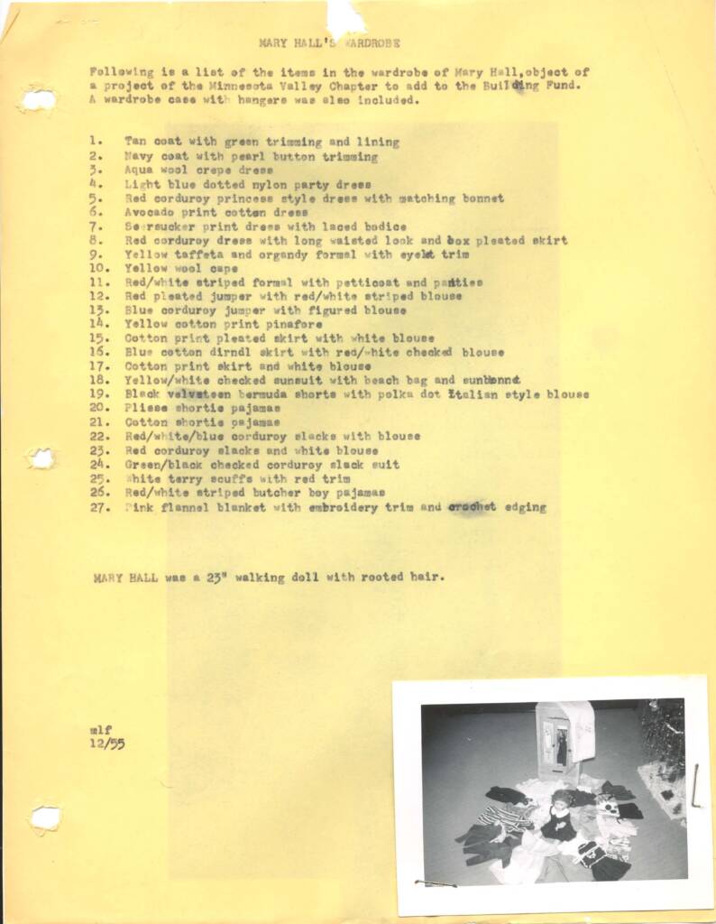 A typed list on yellow paper titled "Mary Hale's Wardrobe" describes a doll's clothing. Items include dresses, coats, and accessories. A black and white photo at the bottom shows the doll with outfits displayed around it.