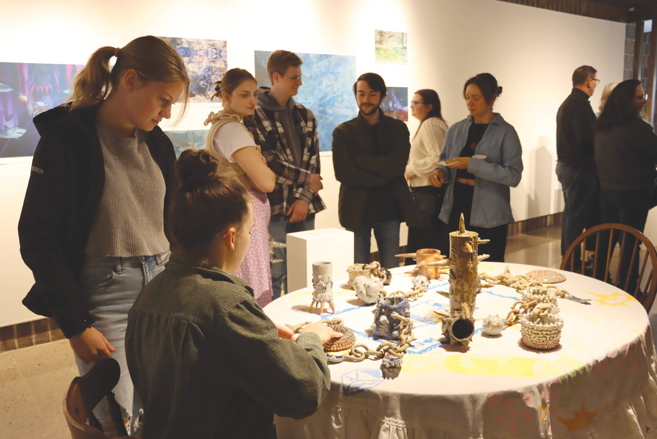 college students looking at art on a table