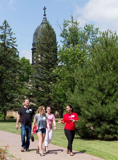 people visiting campus with csb monastery in background