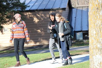 Three college students walking outside a building