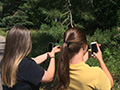 Two women taking pictures of nature