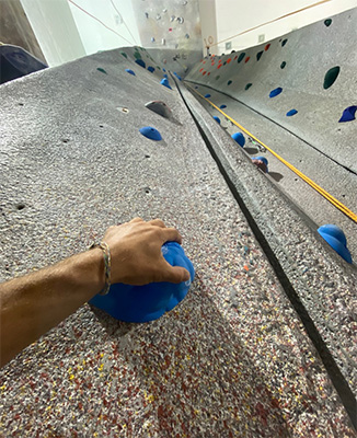 image of hand of person on wall, preparing to climb