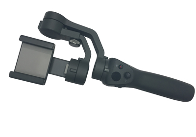 A black handheld smartphone gimbal stabilizer is shown against a white background. The gimbal features an adjustable clamp for holding the phone, and its handle contains various controls and buttons for operation.