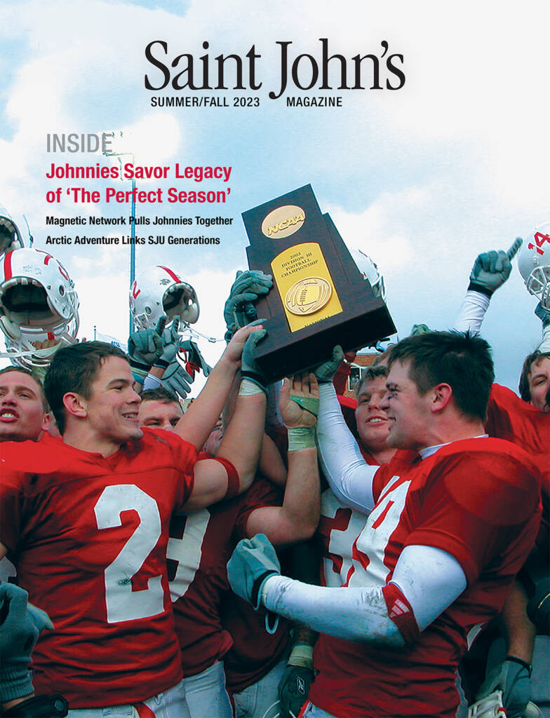 The cover of Saint John's Summer/Fall 2023 magazine features a jubilant football team in red uniforms holding a championship trophy. The headline reads: "Johnnies Savor Legacy of 'The Perfect Season.'.