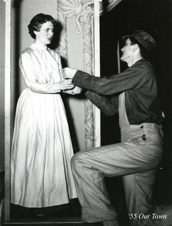 A man wearing overalls kneels and gestures earnestly towards a woman in a long dress. They are on stage with a simple set. The scene is theatrical, likely from the play "Our Town." The image has "’55 Our Town" written in the corner.