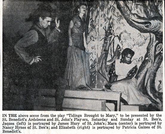 A black and white photo of three actors performing a scene from the play "Tidings Brought to Mary." One man stands to the left, a woman stands on a platform in the center, and another woman sits on a bench to the right, with a painted backdrop behind them.