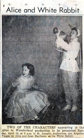 Vintage photo of two actors portraying Alice and the White Rabbit from "Alice in Wonderland." Alice, in a dress, sits on stage, while the White Rabbit, in a costume with a horn, stands beside her. Text above reads "Alice and White Rabbit.