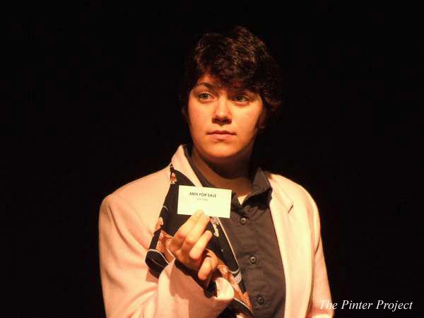 Person in a suit holding a small card that reads, "NOT FOR SALE," under a spotlight against a dark background. Text "The Pinter Project" is at the bottom right.