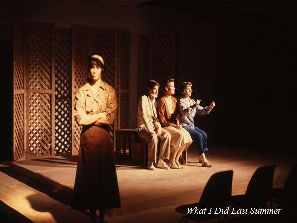 Stage scene with four actors on a minimalist set. One actor stands in the foreground wearing a cap and long skirt, while three others are seated behind, facing the audience. The backdrop is a lattice partition. The caption reads "What I Did Last Summer.