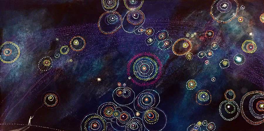 A cosmic-themed painting featuring a starry night sky with swirling, colorful, concentric circles of dots. The background is a deep blue with faint hints of celestial clouds. In the lower-left corner, a small figure is standing, reaching towards the sky.