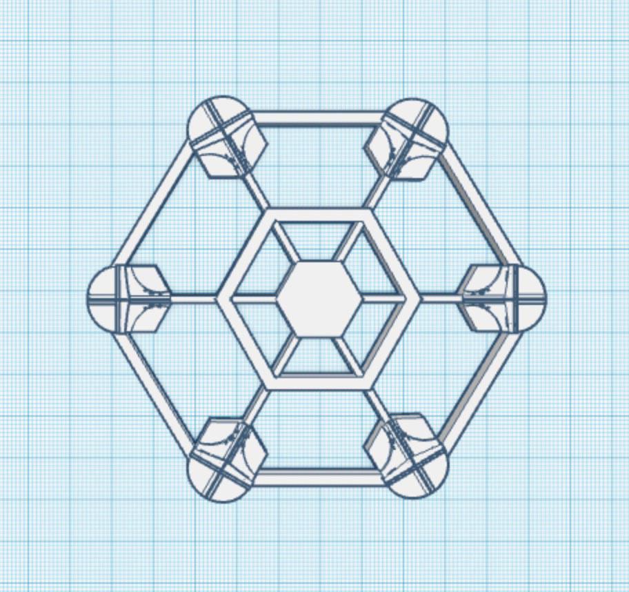 Technical drawing of a geometric design with a central hexagon surrounded by a larger hexagon. The larger hexagon is connected to circles at each corner, each circle divided into quarters by lines. The background is graph paper with faint blue grid lines.