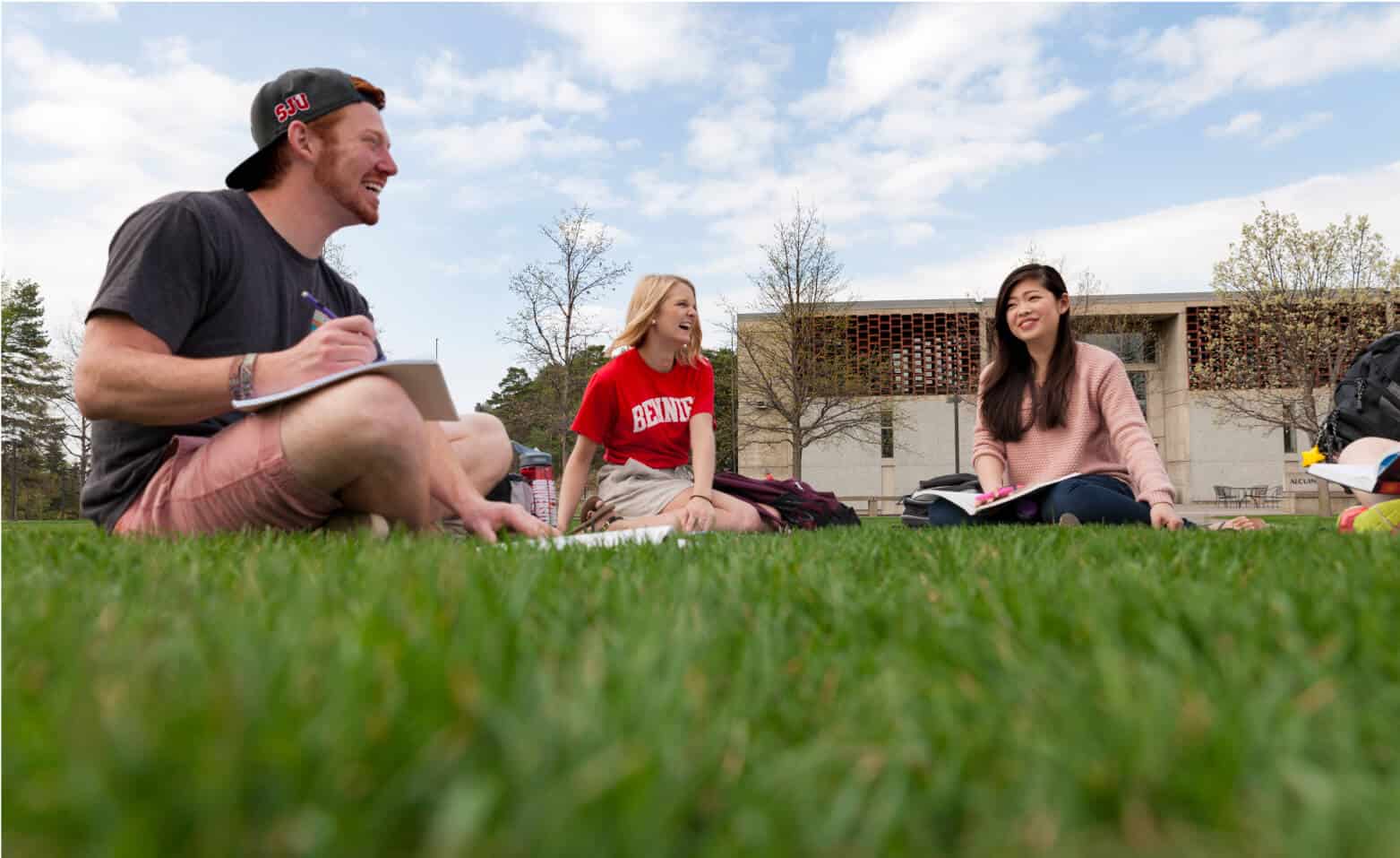 Happy students enjoy the weather and study outside.